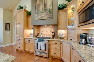 a kitchen with wooden cabinets and a stove at Furnished Decks and Grill Peaceful Pioneer Home! in Pioneer