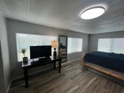 a bedroom with a bed and a desk with a television at The Sequoia guesthouse in Miramonte