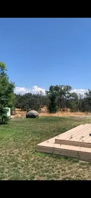 a wooden platform in a field with trees in the background at The Sequoia guesthouse in Miramonte
