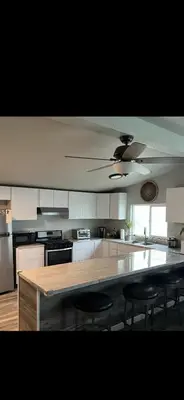 a kitchen with a large counter with chairs in it at The Sequoia guesthouse in Miramonte