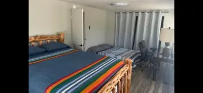 a bedroom with a wooden bed with a striped blanket at The Sequoia guesthouse in Miramonte