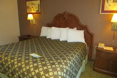 a hotel room with a large bed with white pillows at American Inn Stockton in Stockton