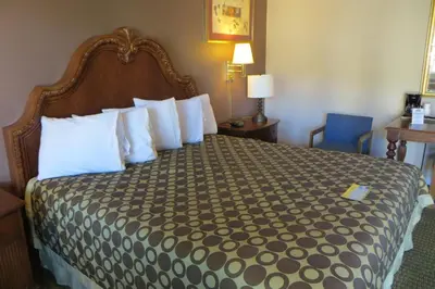 a bedroom with a large bed with white pillows at American Inn Stockton in Stockton