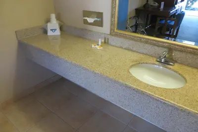 a bathroom counter with a sink and a mirror at American Inn Stockton in Stockton