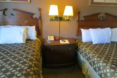 a hotel room with two beds and two lamps at American Inn Stockton in Stockton