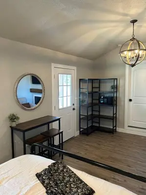 a bedroom with a bed and a mirror and a table at Adorable One Bedroom Cottage in Oakdale