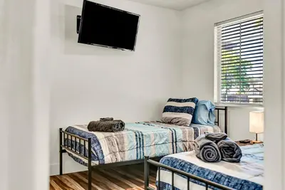 a bedroom with two beds and a flat screen tv at Magnolia Peaceful Vibes Cozy Near Hospital in Hanford