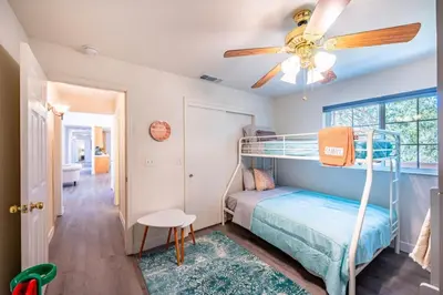 a bedroom with a bunk bed and a ceiling fan at Manic Mountain Forest Cabin 3 miles from Bass Lake in Oakhurst