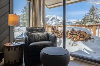 a room with a chair and a table and a window at Snowcreek II 2 plus loft 2 bathroom end unit condo sleeping 8 people with amazing mountain view in Mammoth Lakes
