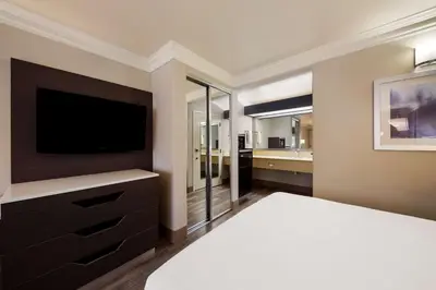 a bedroom with a bed with a television and a bathroom at Best Western Inn & Suites Lemoore in Lemoore