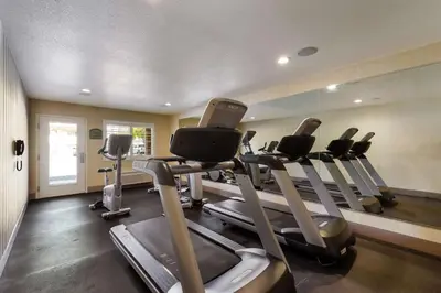 a gym with treadmills and ellipticals in a room at Best Western Inn & Suites Lemoore in Lemoore