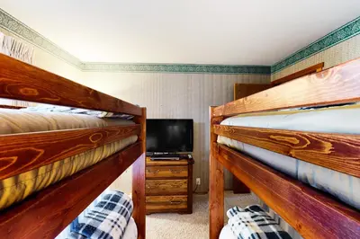 two bunk beds in a room with a tv at Snowcreek 234 in Mammoth Lakes