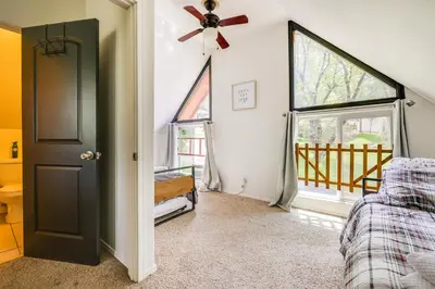 a living room with a ceiling fan and windows at Groveland Vacation Rental about 24 Mi to Yosemite! in Groveland