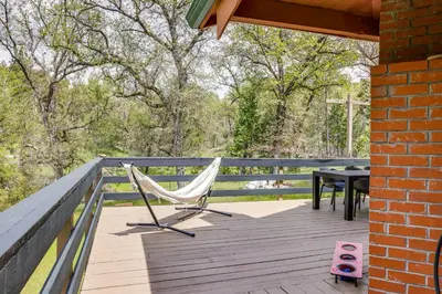 a hammock on the deck of a house with a table at Groveland Vacation Rental about 24 Mi to Yosemite! in Groveland
