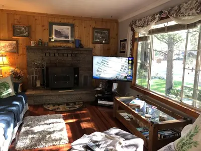 a living room with a fireplace and a tv at Tahoe Cottage perfect for couples and outdoor enthusiasts in South Lake Tahoe