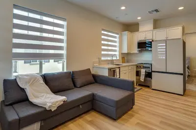 a living room with a couch and a kitchen at California Midterm Rental with Fenced Yard! in Tracy