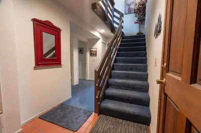 a hallway with a staircase with a red mirror at Rr-edgewater06 in June Lake