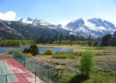 a tennis court next to a lake with snow capped mountains at Rr-interlaken 25 in June Lake