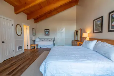 a bedroom with a large white bed and wooden floors at Rr-interlaken 17 in June Lake