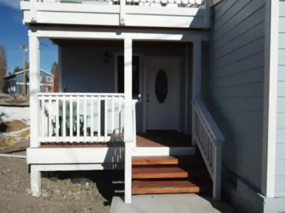 a porch with a white railing and stairs on a house at Rr-gull Lake Baby House in June Lake