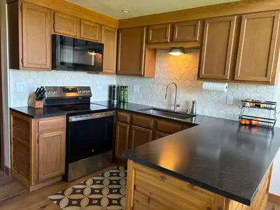 a kitchen with wooden cabinets and a black counter top at Rr-edgewater09 in June Lake