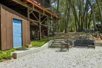 a house with two chairs and a blue door at Hike, Bike and Golf Peaceful Cabin in Twain Harte! in Twain Harte