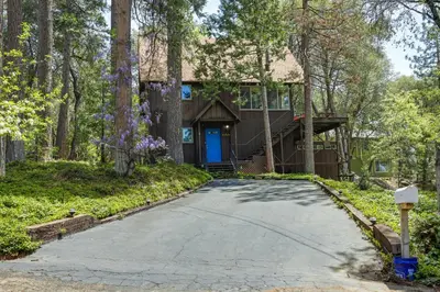 a driveway leading to a house with a blue door at Hike, Bike and Golf Peaceful Cabin in Twain Harte! in Twain Harte