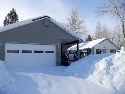 a garage covered in snow next to a house at Elk House in June Lake