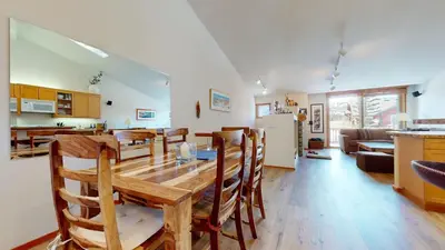 a kitchen and living room with a wooden table and chairs at Snowcreek V #784 condo in Mammoth Lakes