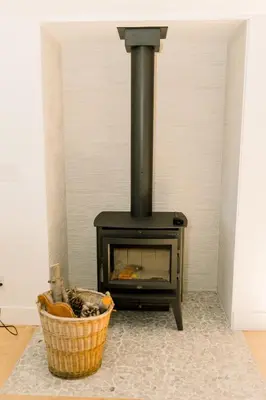 a wood stove with a basket in front of it at Casita- Lake Area Winter Special Ends 51626 in Bass Lake
