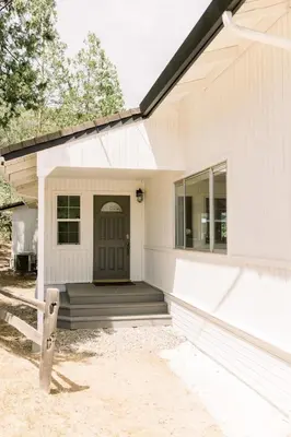 a white house with a porch and a door at Moreno-Lake Area Free Night Special in Bass Lake