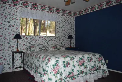a bedroom with a bed with floral wallpaper and a window at Cedar-Lake Area Winter Special Ends 51626 in Bass Lake