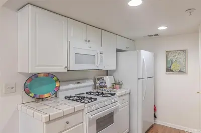 a white kitchen with a stove and a refrigerator at Rosenberg Slide Creek Reduced Nightly Rate in Bass Lake
