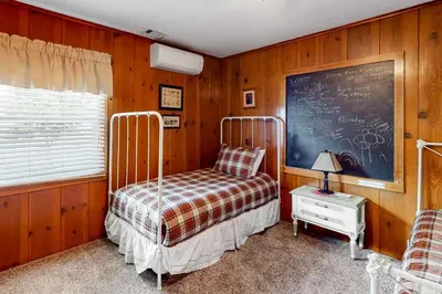 a bedroom with a bed and a chalkboard on the wall at Wilts Happy Place in Bass Lake