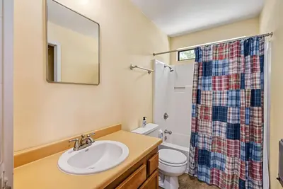 a bathroom with a sink and a toilet and a mirror at Marina Beach Lodge - Lakefront Home on Beach! home in Groveland