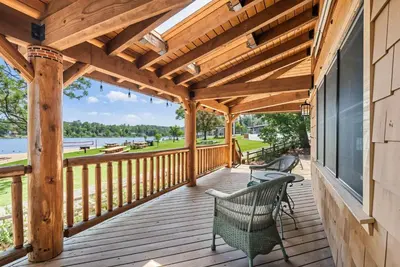 a wooden deck with two chairs on it at Marina Beach Lodge - Lakefront Home on Beach! home in Groveland