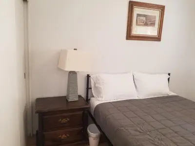 a bedroom with a bed and a lamp on a nightstand at 3BR Panoramic Lake View, Sequoia Forest, Kern County in Wofford Heights