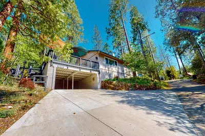 a house with a driveway in front of it at Casa de la Montaña in Bass Lake