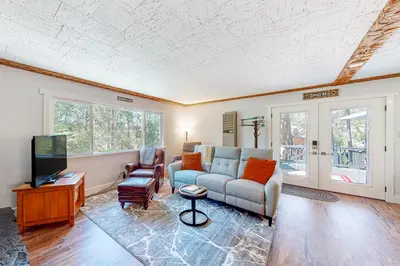a living room with a couch and a tv at Casa de la Montaña in Bass Lake