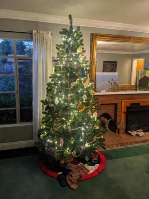 a christmas tree in a living room with a fireplace at The Parks Inn in Three Rivers