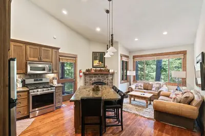 a kitchen and living room with a couch and a table at Northstar Ski in Ski out 2BR Condo in Truckee