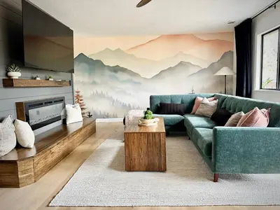 a living room with a blue couch and mountains mural at Prime location Yosemite Expedition by Casa Oso in Oakhurst