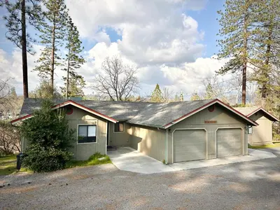 a house with a car garage in a driveway at Prime location Yosemite Expedition by Casa Oso in Oakhurst