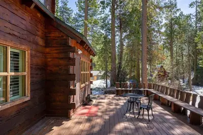 a porch of a log cabin with a table and chairs at 3BR Mountain Cabin-Near Beach & Slopes in Homewood