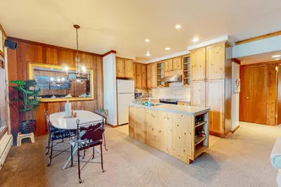 a kitchen with wooden cabinets and a table with chairs at Mountain Time Escape in Olympic Valley