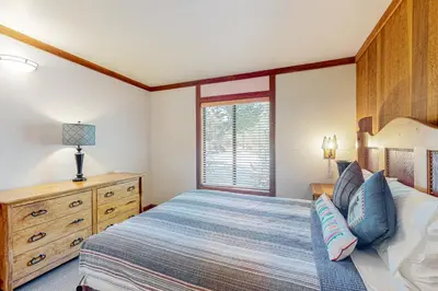a bedroom with a bed and a dresser and a window at Mountain Time Escape in Olympic Valley