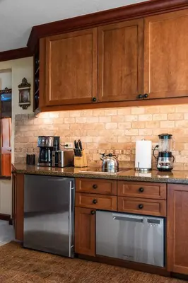 a kitchen with wooden cabinets and a stainless steel dishwasher at Everline Resort & Spa 701 & 703 in Olympic Valley