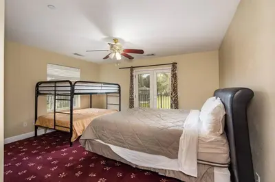 a bedroom with a bed and a ceiling fan at Yosemite South Presidential Mansion in Coarsegold