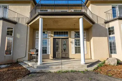 a house with a front door with a balcony at Yosemite South Presidential Mansion in Coarsegold