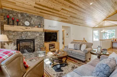 a living room with a stone fireplace and furniture at Tahoe Discovery in South Lake Tahoe